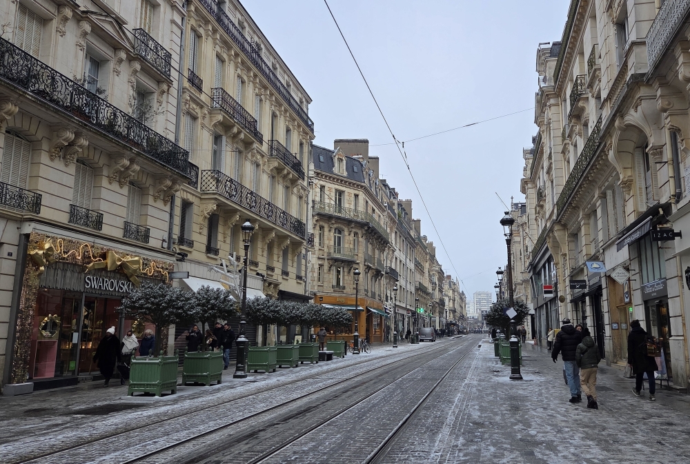Cobblestone street in Orléans, France, with historic buildings and outdoor cafés